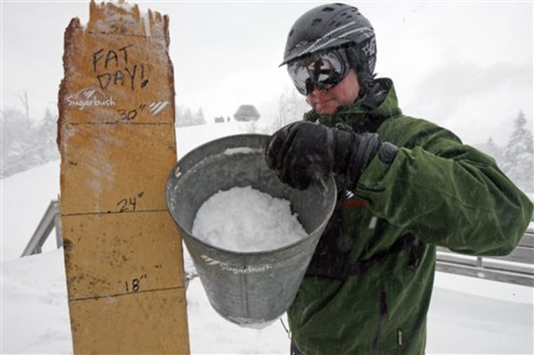 JJ Toland, communications director for the Sugarbush ski resort, holds the maple sap bucket used for measuring snowfall in Warren, Vt., on Jan. 20. 